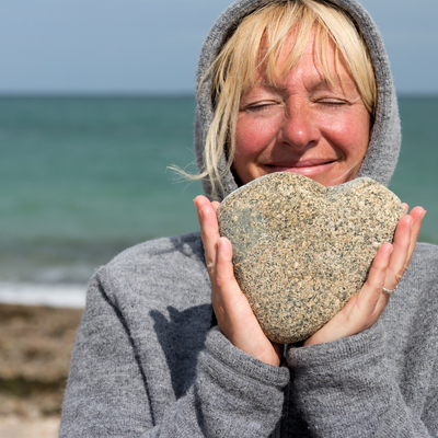 woman on beach holding stone