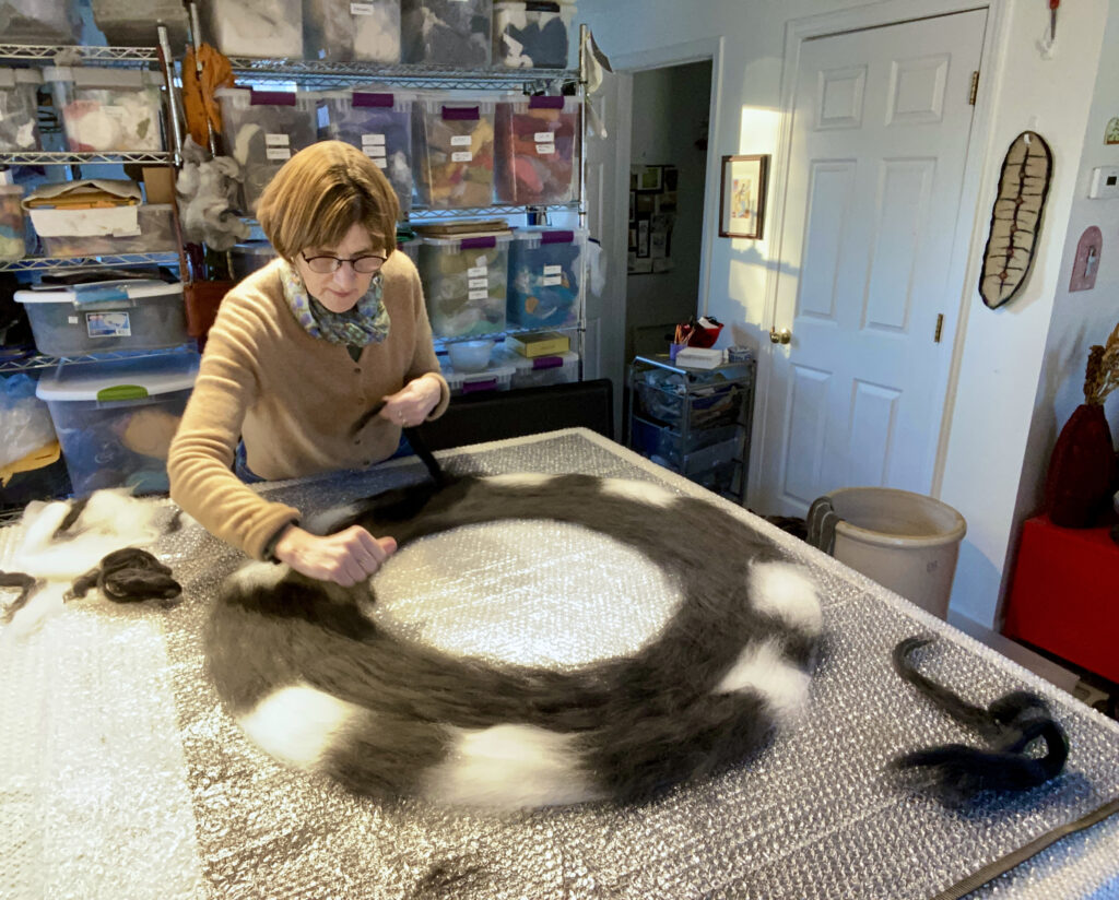 Judy Daniels sculpting and molding wool into vases.